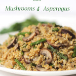 White plate filled with Freekeh with mushrooms and asparagus with green herbs in the background.