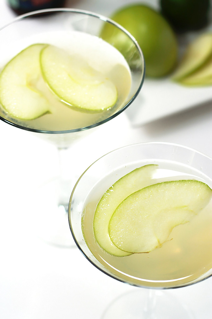 Apple Beer Cocktails in two martini glasses garnished with apple slices.