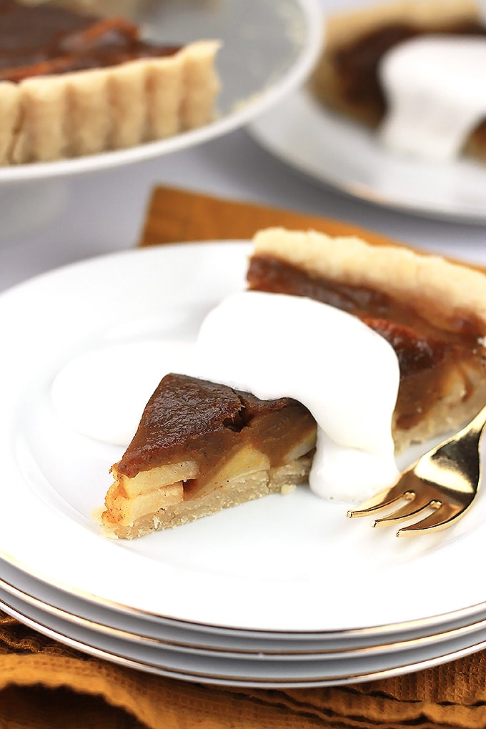 Slice of pumpkin apple tart with coconut cream on top. 