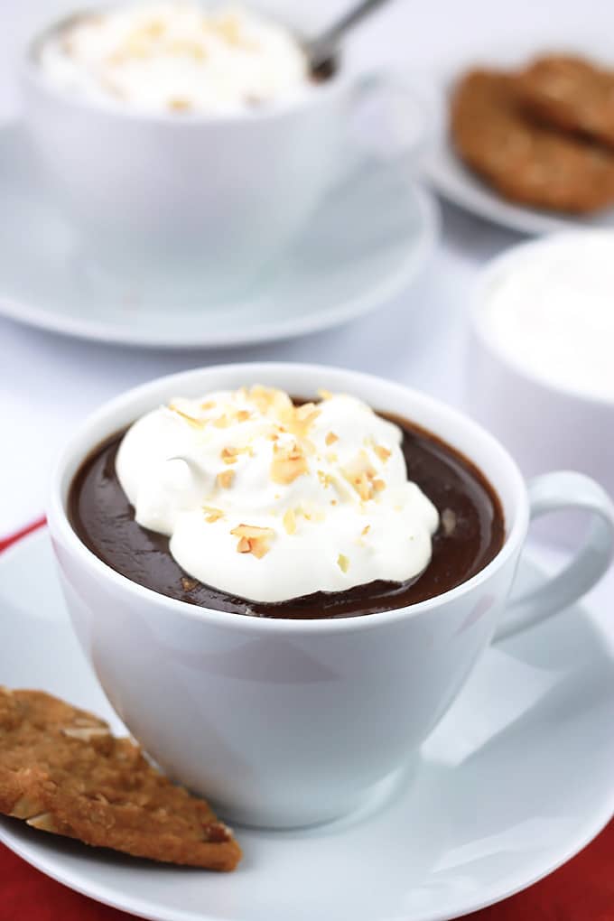 Cozy up with a cup of Decadent Dairy-Free Hot Chocolate topped with creamy coconut cream and toasted coconut.