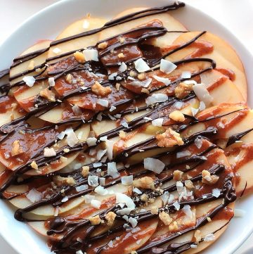 Apple Nachos with Vegan Caramel Sauce - Layers of sweet crisp apple slices garnished with smooth vegan caramel, dark chocolate, walnuts and coconut. It's like eating a delicious candy apple.