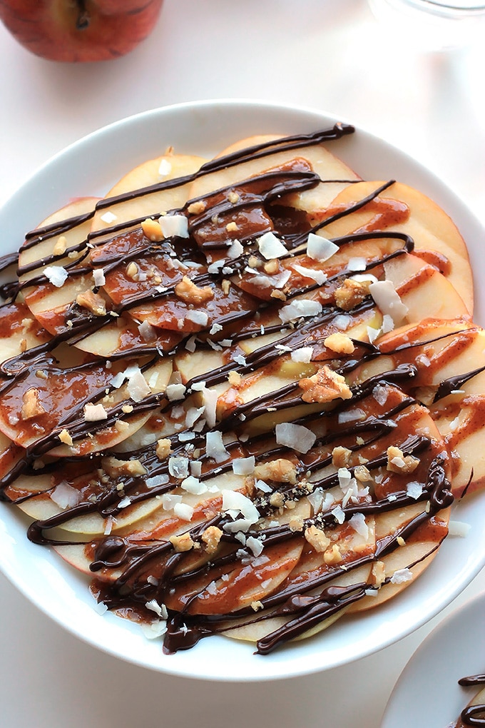 Apple Nachos with Vegan Caramel Sauce - Layers of sweet crisp apple slices garnished with smooth vegan caramel, dark chocolate, walnuts and coconut. It's like eating a delicious candy apple.