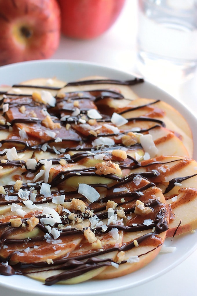 Apple Nachos with Vegan Caramel Sauce - Layers of sweet crisp apple slices garnished with smooth vegan caramel, dark chocolate, walnuts and coconut. It's like eating a delicious candy apple.