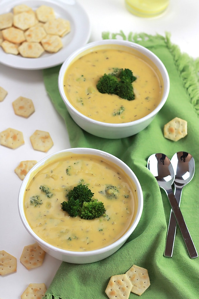 Two bowls of Vegan Un-Cheesy Potato Broccoli Soup with broccoli on top and crackers.
