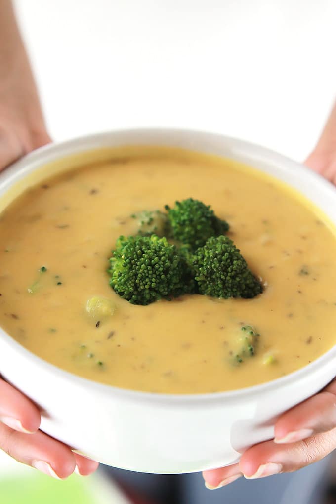 Bowl of Vegan Un-Cheesy Potato & Broccoli Soup with broccoli florets on top.