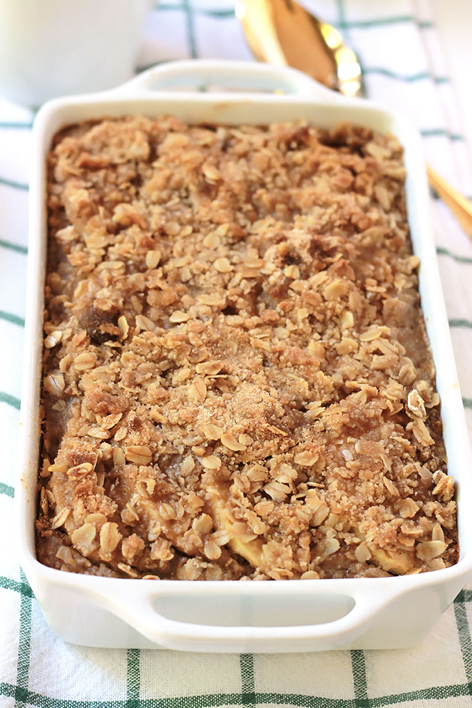  Apple Cinnamon Baked Oatmeal on a dish towel with gold serving spoon.