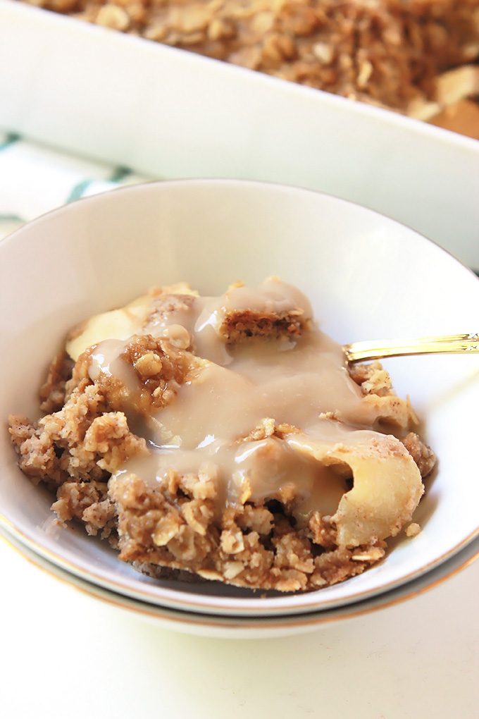 Bowl of Apple Cinnamon Baked Oatmeal topped with brown sugar sauce. 