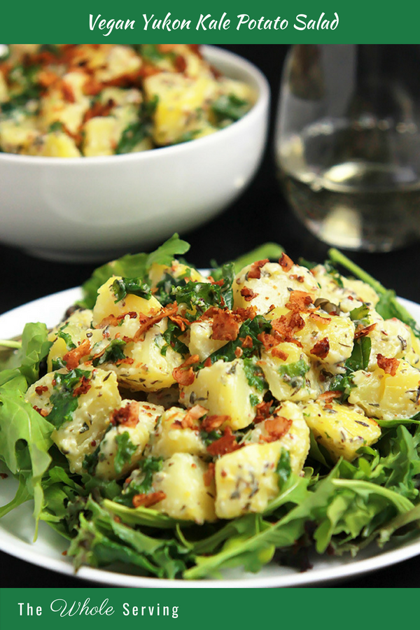 Vegan Yukon Kale Potato salad on white plate with vegan coconut bacon on top.