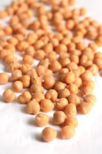 cooked chickpeas scattered on a white table.
