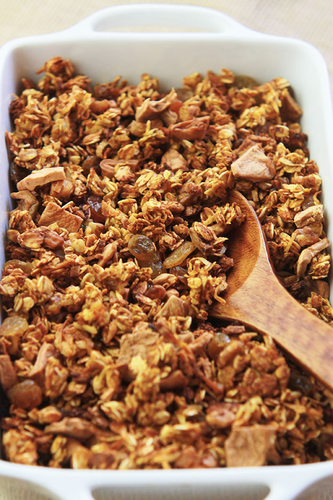 Wooden spoon scooping Pumpkin Apple Cinnamon Granola.