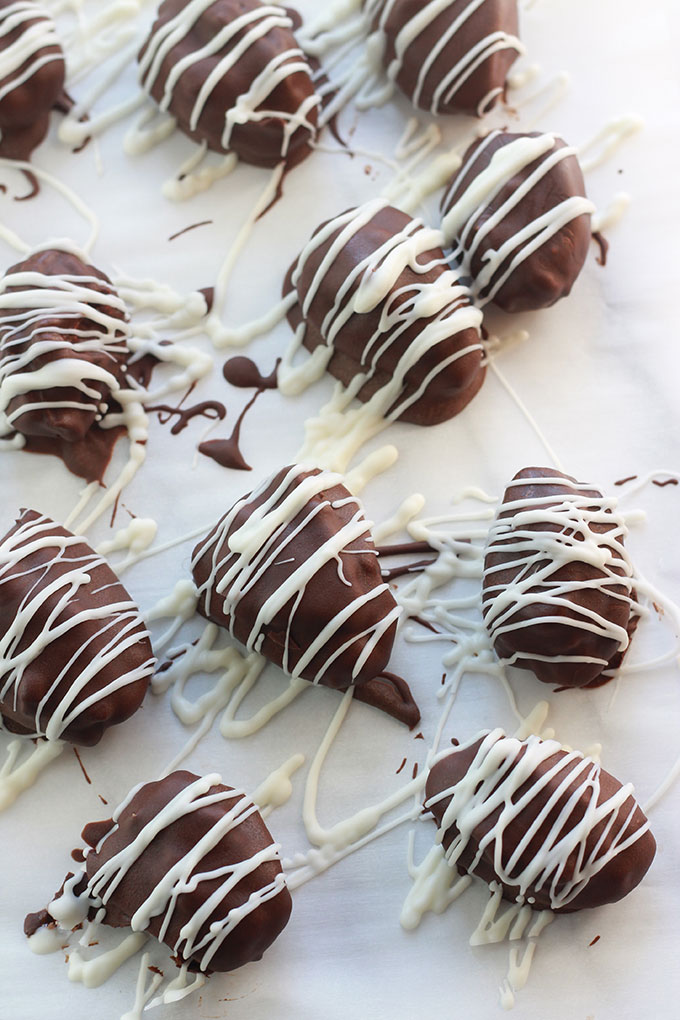 Overhead shot of Chocolate Covered Nut Butter Stuffed Dates drizzled with vegan white chocolate.