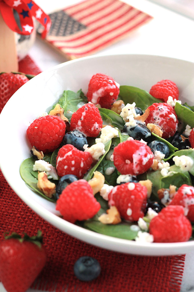 Layers of fruit, creamy goat cheese and lettuce, this Red White & Blue Salad with Poppy Seed Dressing is colorful and perfect for patriotic celebrations.