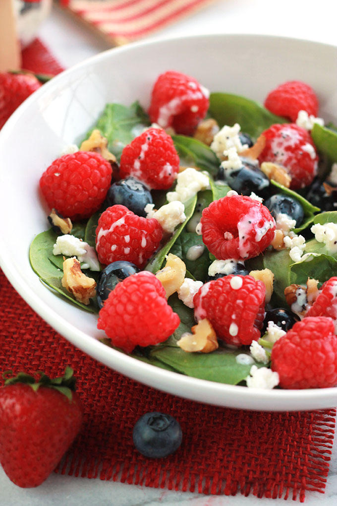 Layers of fruit, creamy goat cheese and lettuce, this Red White & Blue Salad with Poppy Seed Dressing is colorful and perfect for patriotic celebrations.