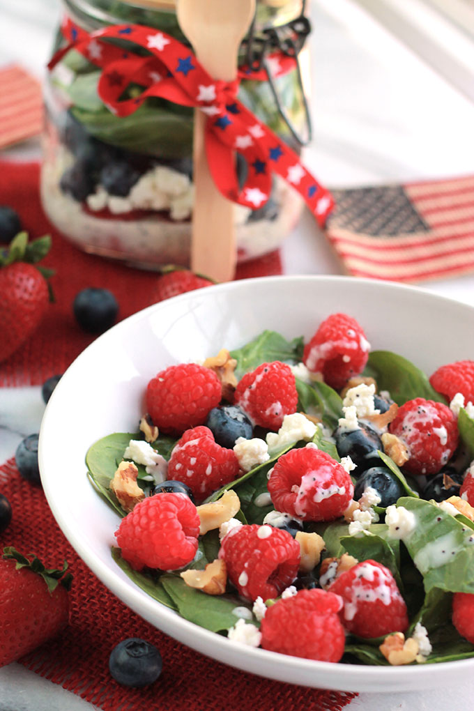 Layers of fruit, creamy goat cheese and lettuce, this Red White & Blue Salad with Poppy Seed Dressing is colorful and perfect for patriotic celebrations.