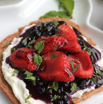 Lightly sweetened creamy lemon ricotta on toast topped with sweet juicy wild blueberry compote, sprinkled with mint. Sumptuosity on a plate.