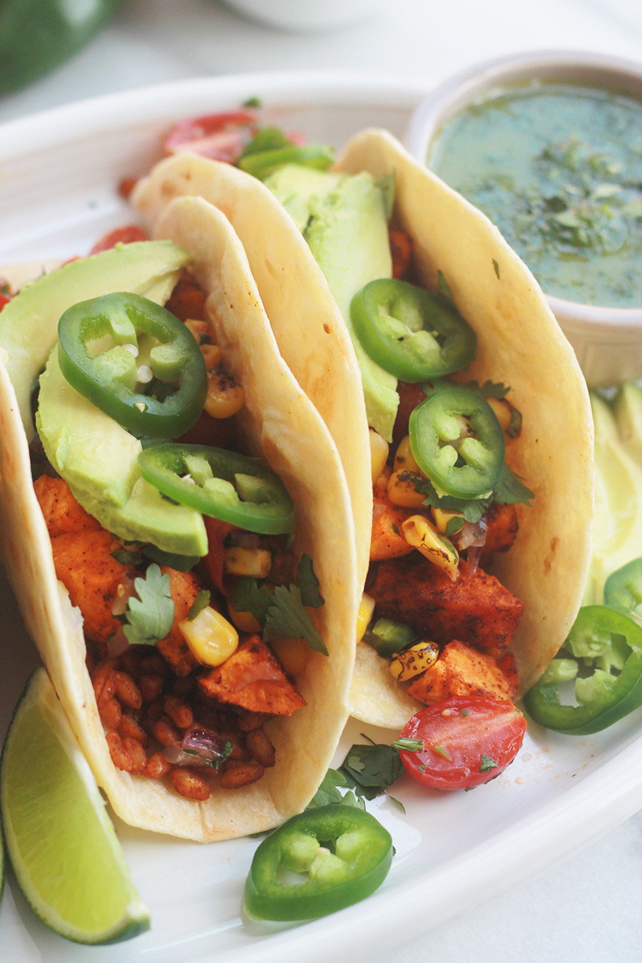 Roasted Sweet Potatoes and Farro Tacos with sliced jalapenos and avocado.