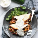 Baked Black Bean Tacos with Red Chile Sauce on plate with vegan sour cream