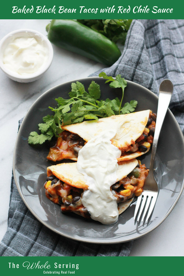 Baked Black Bean Tacos with Red Chile Sauce on plate topped with sour cream.