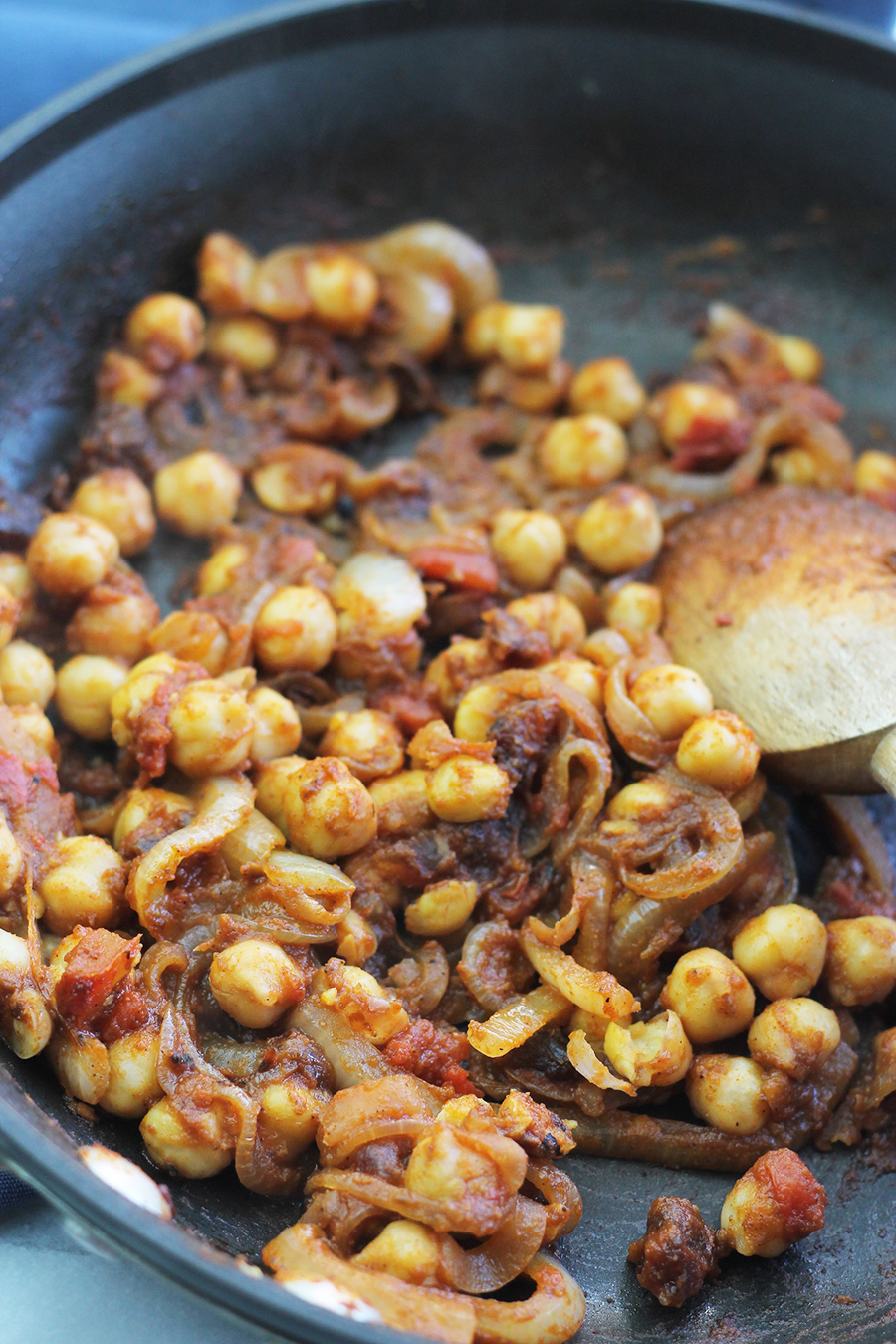 Chickpeas in saute pan, seasoned with Moroccan inspired spice blend.