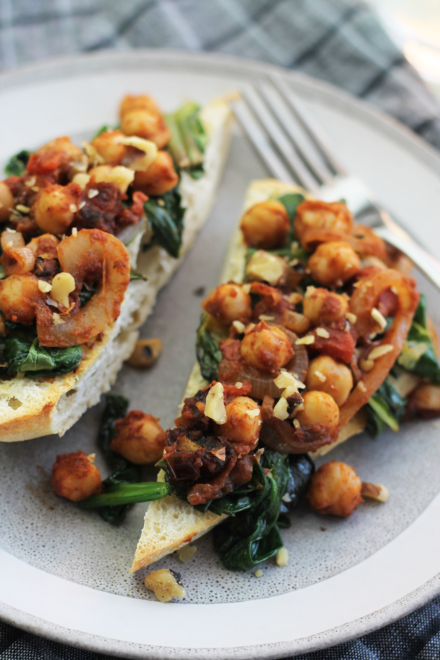 close-up shot of ciabatta garlic toast with spinach, chard and chickpeas on top.