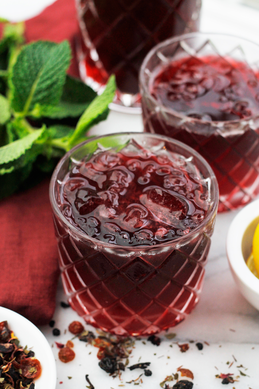 Angled overhead shot of two glasses of Sweet Vermouth Hibiscus Tea Cocktail.