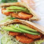 Spicy roasted sweet potatoes, cucumber slaw, and avocado slices inside pita pocket.