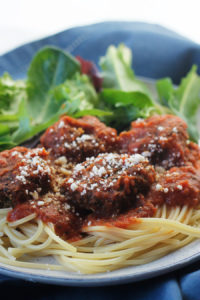 Close-up of easy meatless meatballs over pasta and pasta sauce.