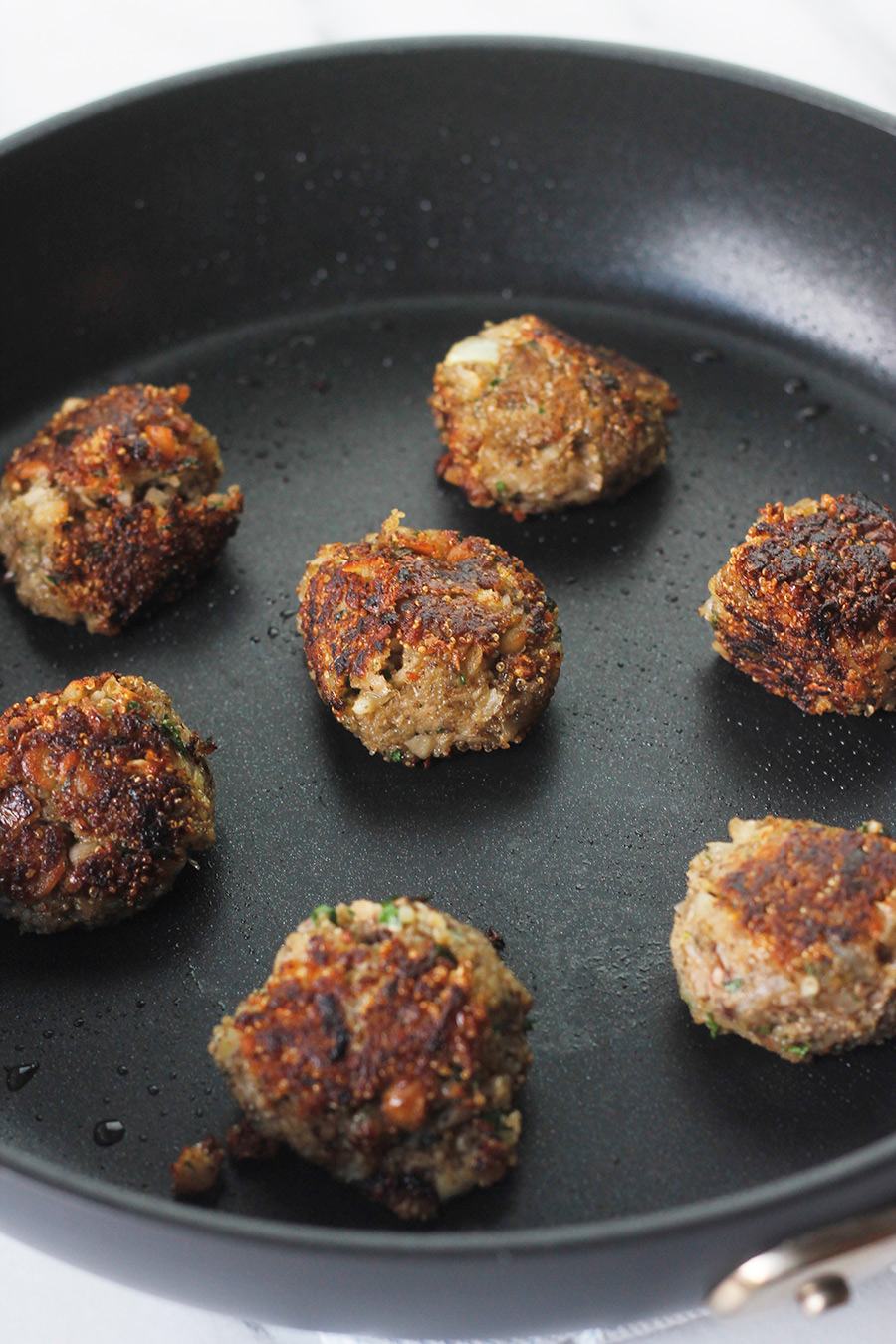 Easy meatless meatballs cooking in nonstick skillet.