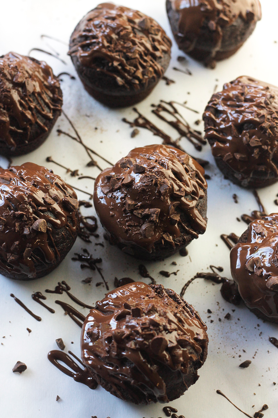 Overhead shot of Chocolate-on-Chocolate Vegan Cupcakes drizzled with melted chocolate and chopped chocolate pieces.