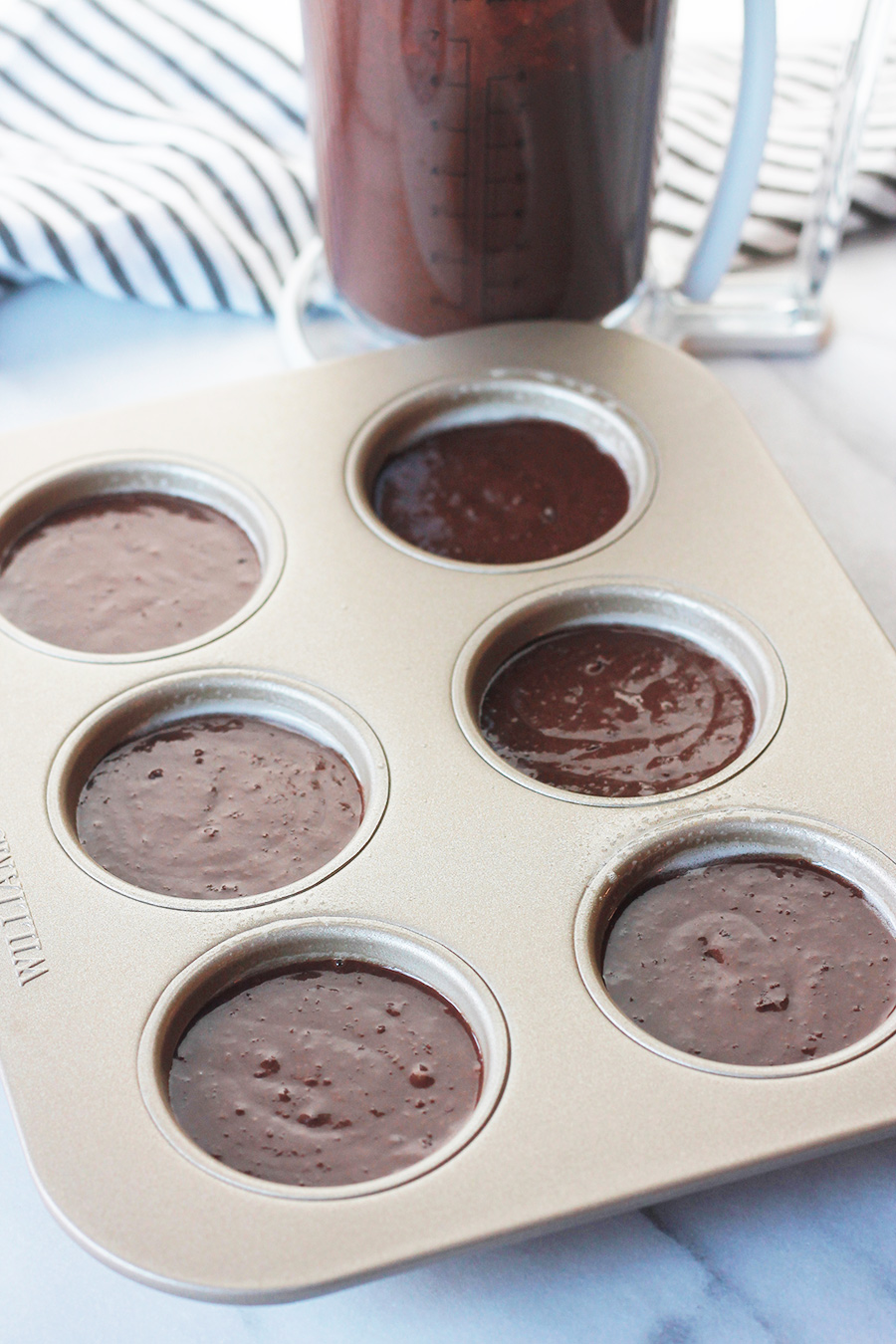 Overhead shot of chocolate-on-chocolate vegan cupcake batter in non-stick muffin pan.