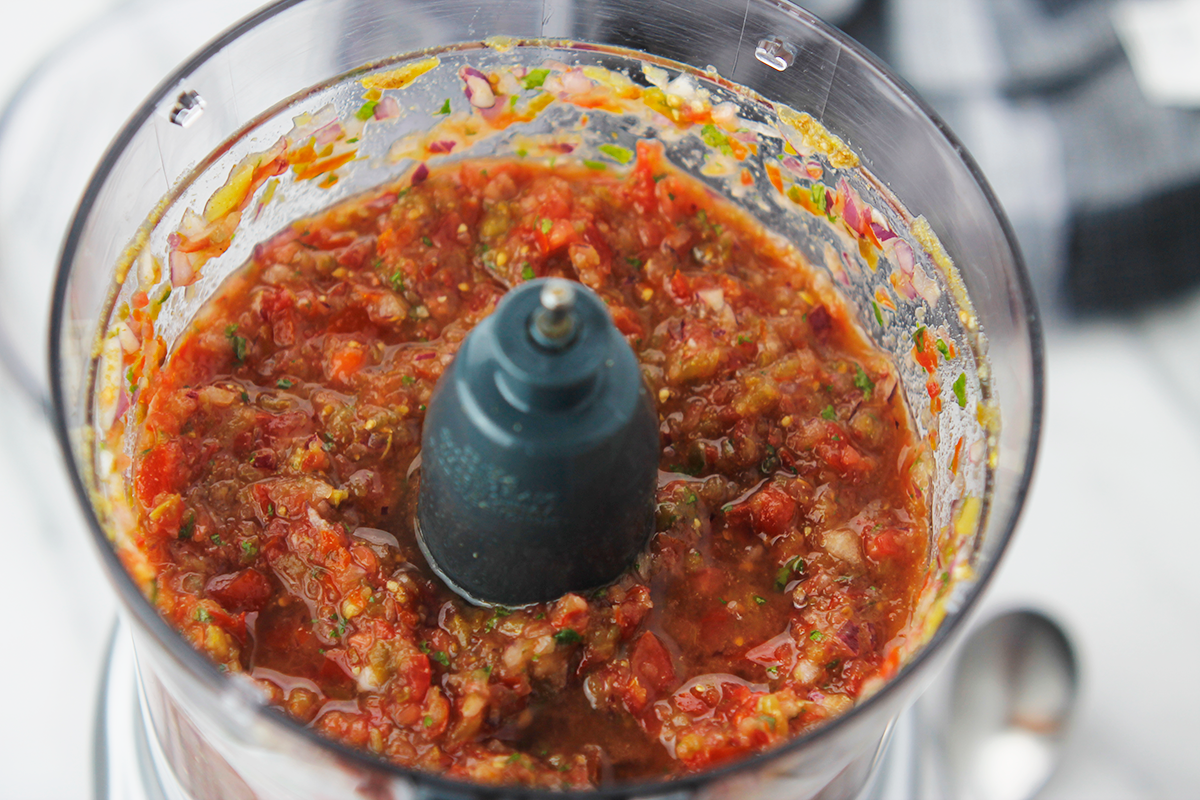 Chopped salsa in food processor bowl.