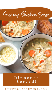 Overhead shot of two bowls of creamy rosemary chicken soup. Bowl in the front right has a small white bowl filled with shredded parmesan cheese and the bowl to the back left has a piece of crusty bread on the right side of the bowl.