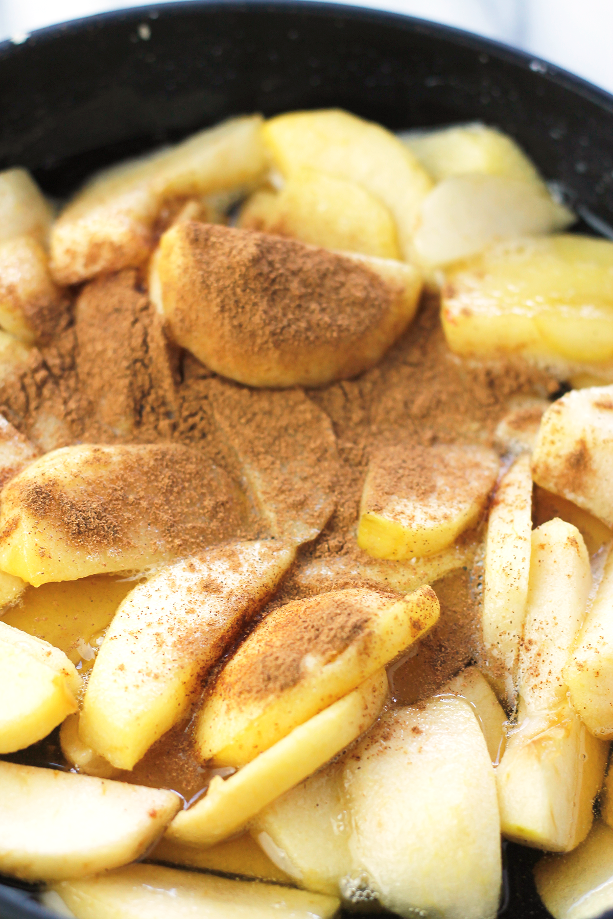 Pan filled with sliced apples with pumpkin pie spice sprinkles on top.