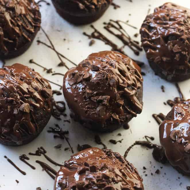 Overhead shot of chocolate-on-Chocolate Vegan cupcakes drizzled with melted chocolate and chopped chocolate pieces.