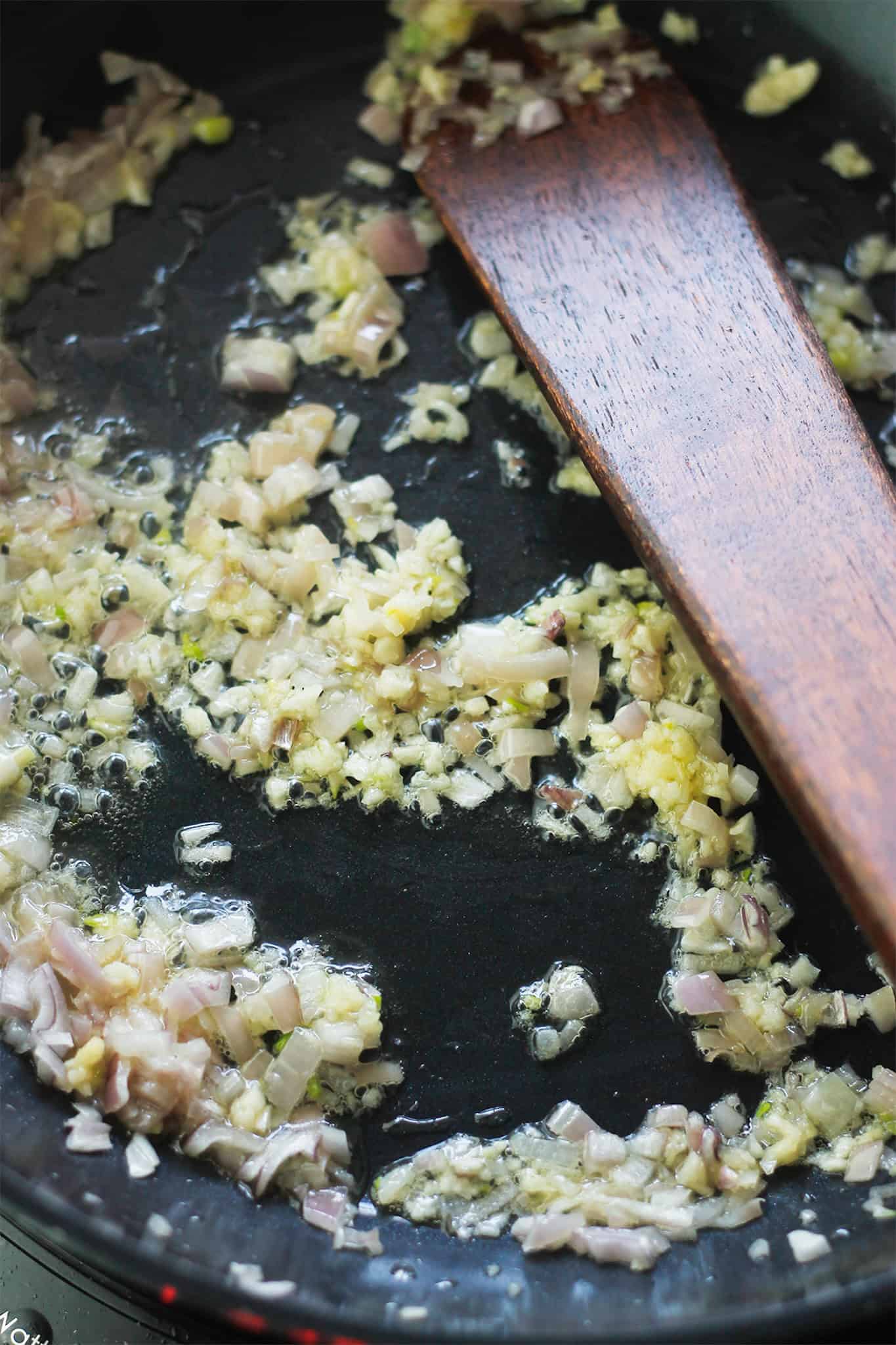 Shallots and garlic sauteing in pan.