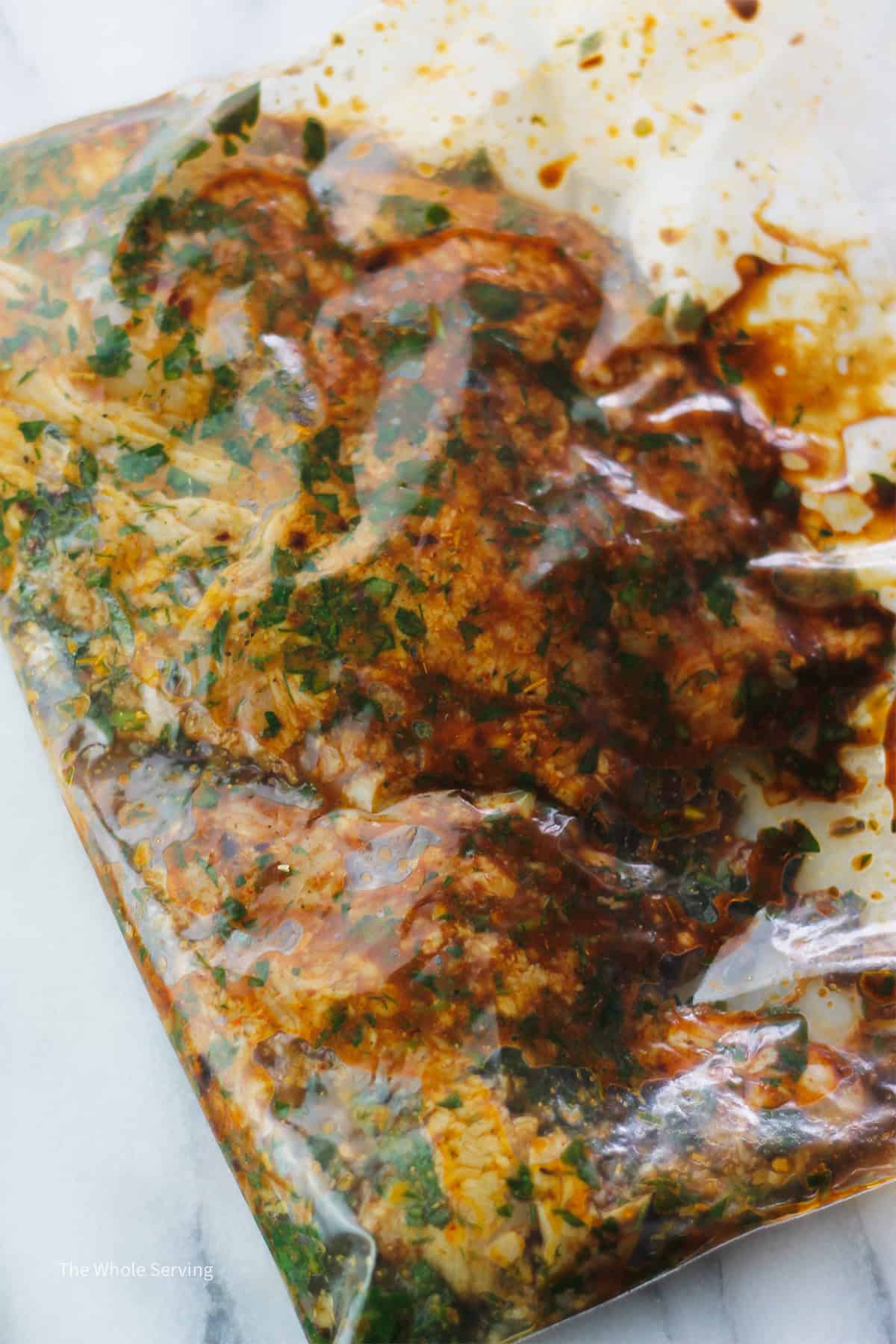 Chicken breast in a zip bag marinating in chimichurri chipotle sauce