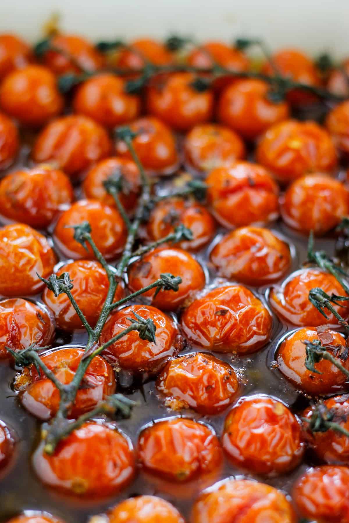 Close-up shot of roasted cherry tomatoes in baking dish.