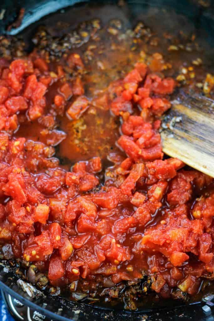 Diced tomatoes added to pan with sautéing shallots, garlic and spices.