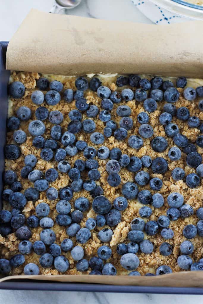 Layer of frozen blueberries on the unbaked crumb cake.