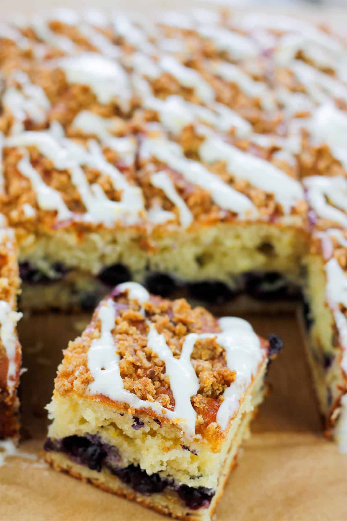 Overhead shot of sliced crumb cake with one square slice in front of cake.