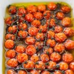 Close-up shot of roasted cherry tomatoes in baking dish.