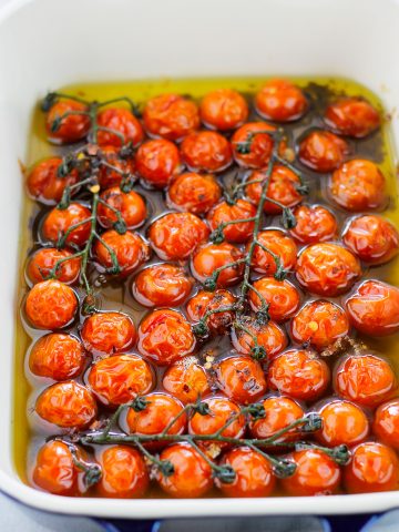Close-up shot of roasted cherry tomatoes in baking dish.