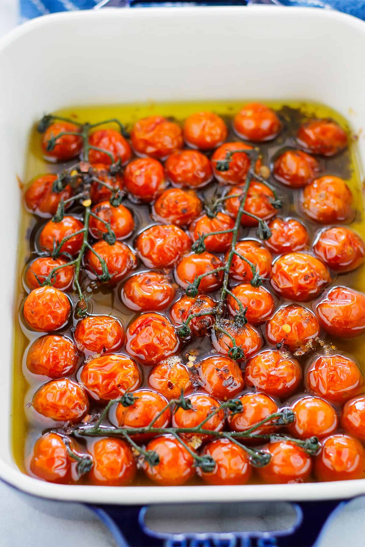 Close-up of roasted cherry tomatoes in baking dish.