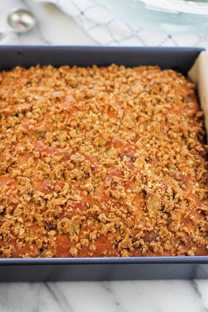 Overhead shot of baked lemon blueberry crumb cake drizzled with cream cheese topping.