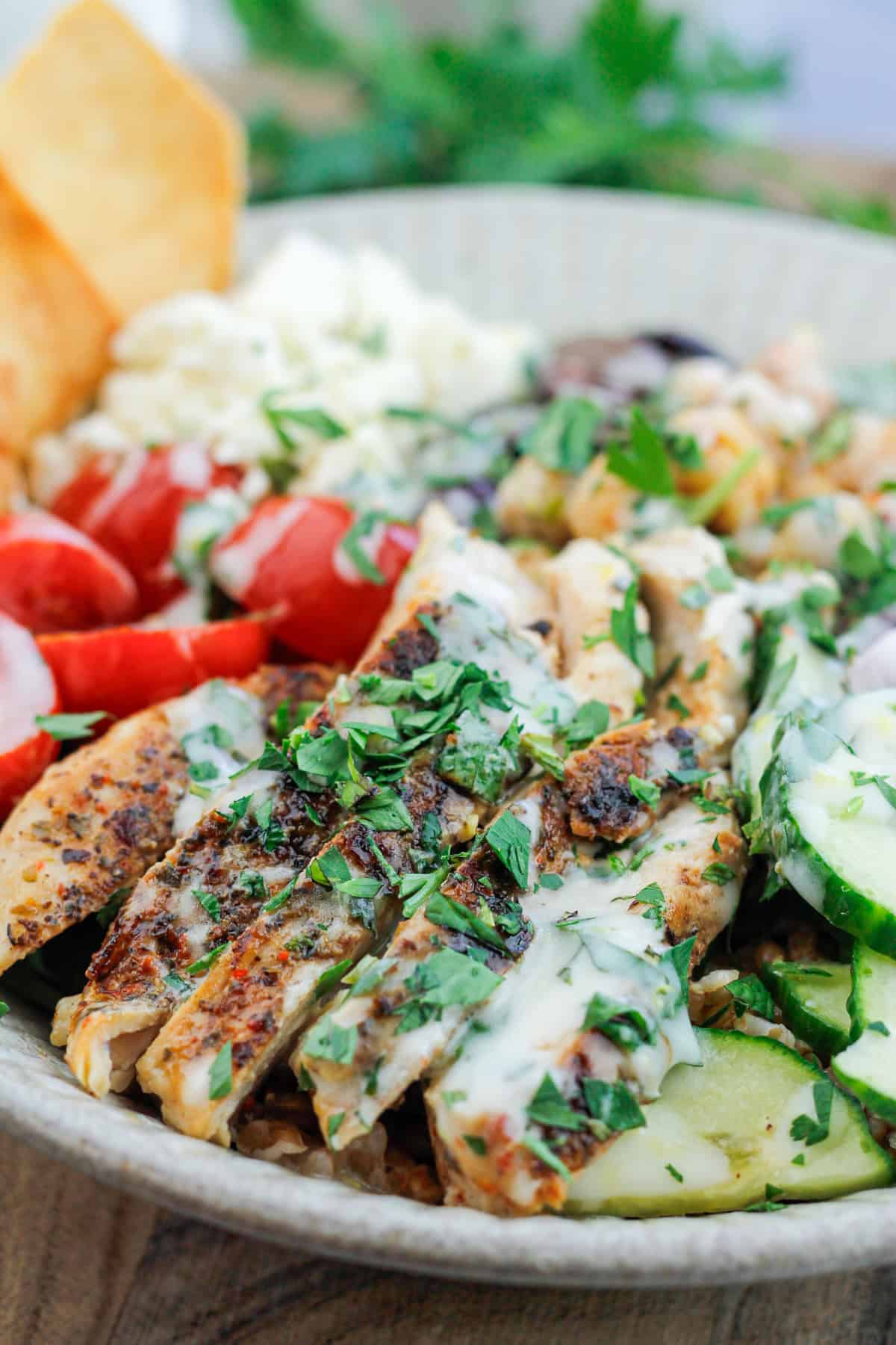 Close-up shot of Mediterranean grain bowl filled with grilled chicken and fresh vegetables