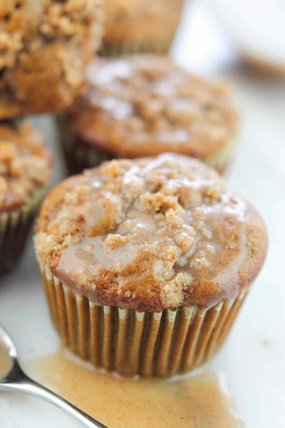 Close-up shot of chai apple muffin with chai glaze poured over front muffin.