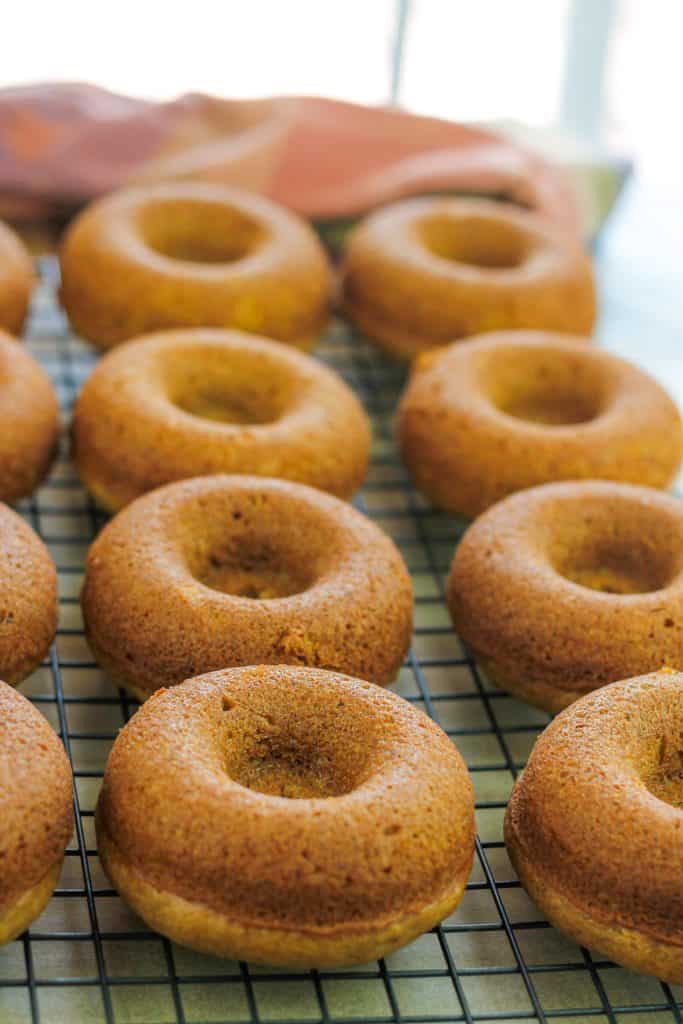 Baked pumpkin dounts on cooling rack.