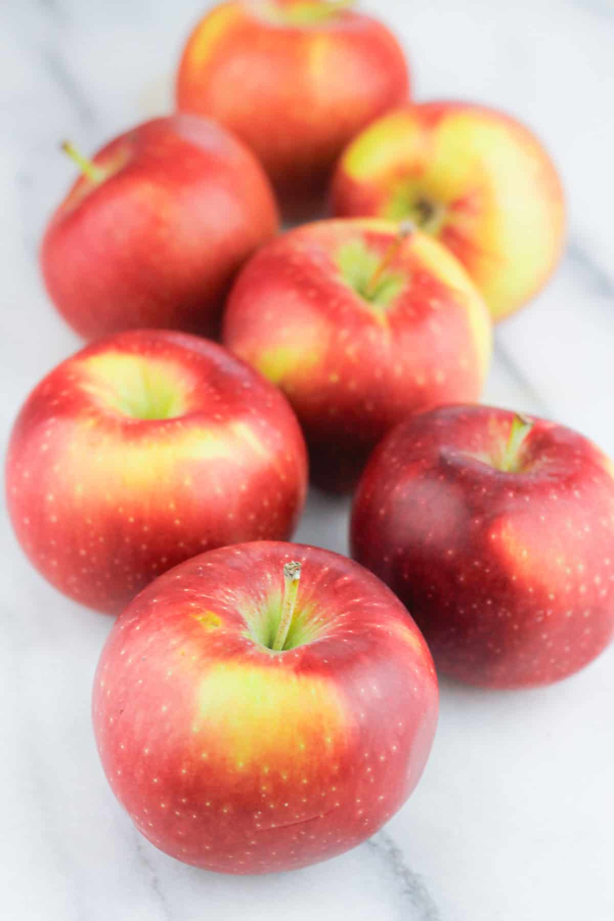 Cluster of fresh apples on a marble countertop.