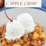 Bowl of pumpkin apple crisp with two scoops of ice cream there are two fresh apples at the back left of the bowl and the corner of the baking dish at the back right of the bowl.