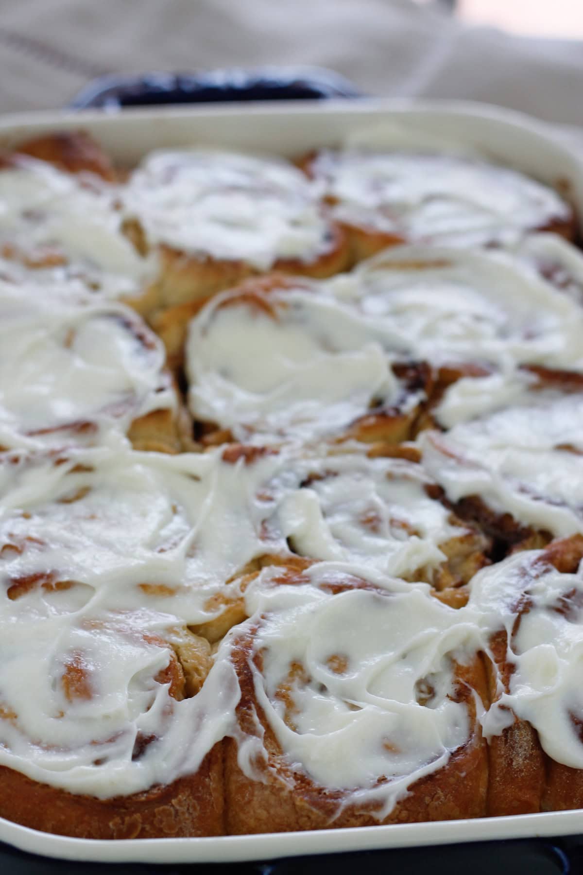 Baked caramel apple cinnamon rolls spread with cream cheese topping.